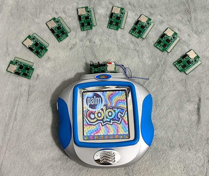 Pixter Color showing rePalm boot screen surrounded by 8 rePalm Pixter Color cartridges